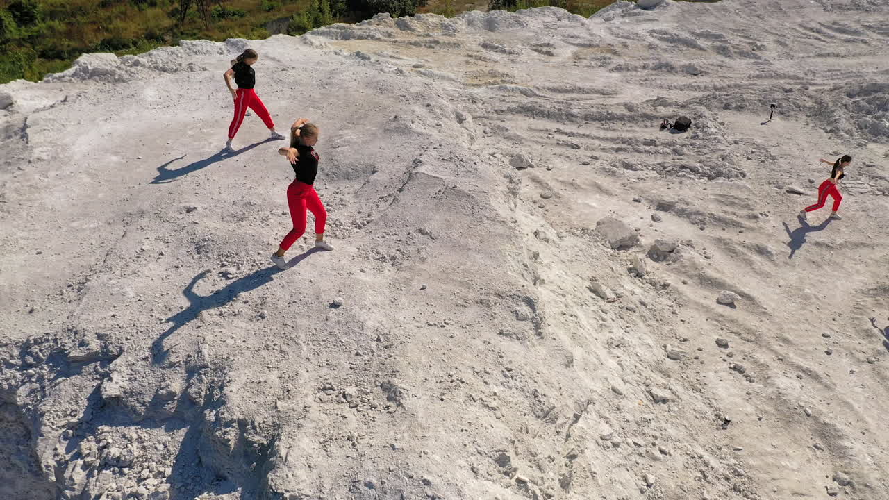 Women Performing Acrobatics on a Hillside