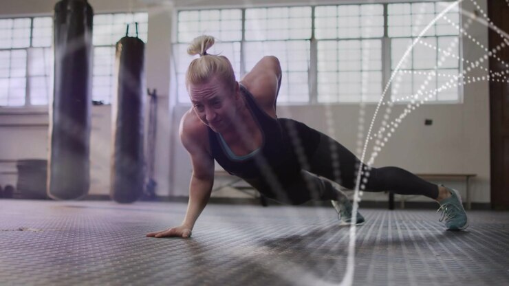 Trainer starting side plank, doing shifts and lowering chest as particle dots sweep, building core