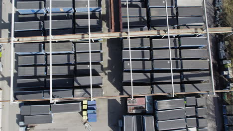 shipping containers standing outside at a industrial compound, top down aerial