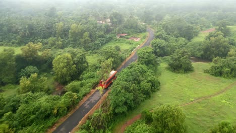 red st bus travel in beautiful village roads in malvan bird view