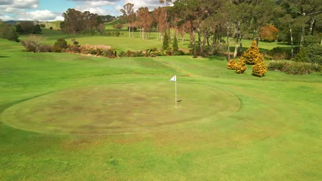 Volando-Alrededor-De-La-Bandera-En-El-Campo-De-Golf-Verde