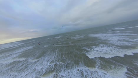 two kitesurfers passing each other, while one of them jumps