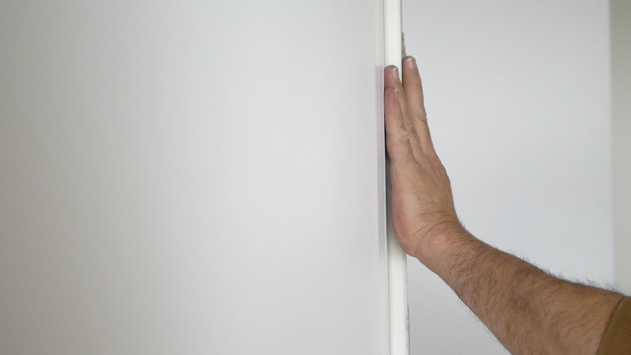 Person Measuring and Marking a Wall