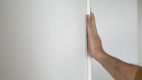 person measuring and marking a wall