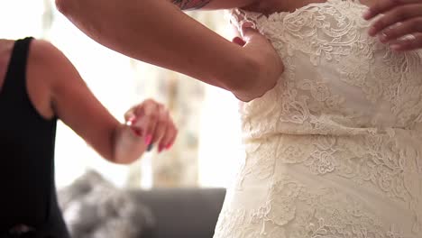 slow motion close up handheld shot of a bride in white wedding dress getting ready for her wedding with her husband to be on her wedding day