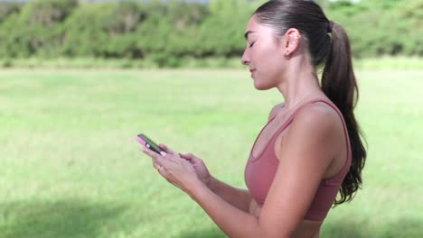 fitness model running up to camera, uses phone, centered