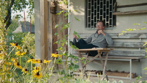 man relaxing on a porch in a garden