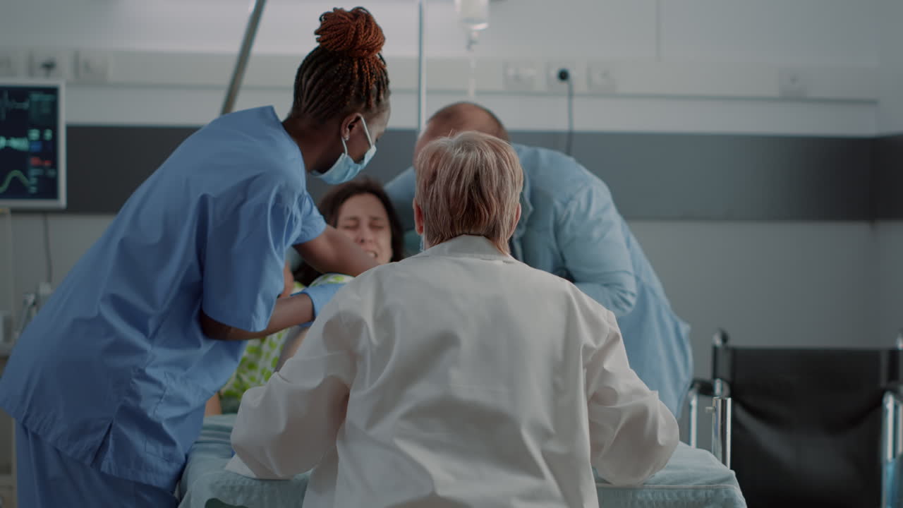 Medico ostetrico e infermiere afroamericano che consegnano il bambino