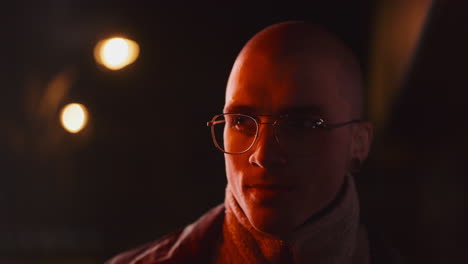 portrait of a man with glasses in warm, low light