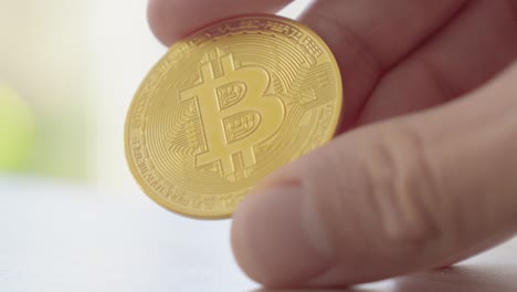 a person holds a bitcoin with a golden structure, symbolizing the strength and value of cryptocurrency in the digital financial world.