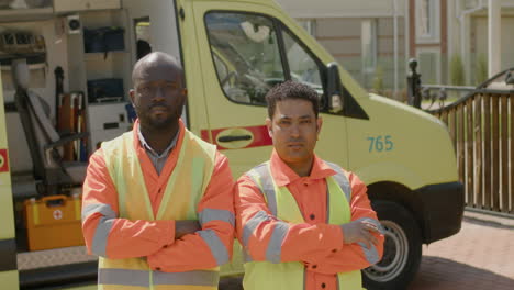 Two-Medical-Assistance-With-Arms-Crossed-Outside-The-Ambulance