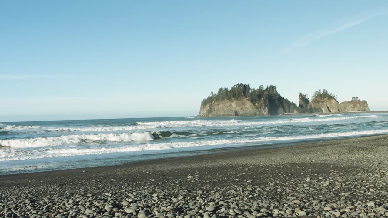 Waves Crashing on Rocky Beach with Island in Background