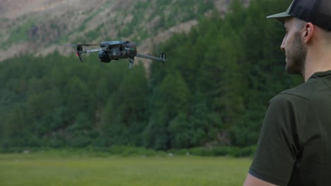 launching a drone from hand, drone operator flying quadcopter outdoors in mountains