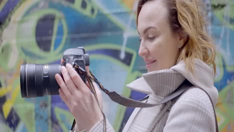 woman taking photo in front of graffiti wall