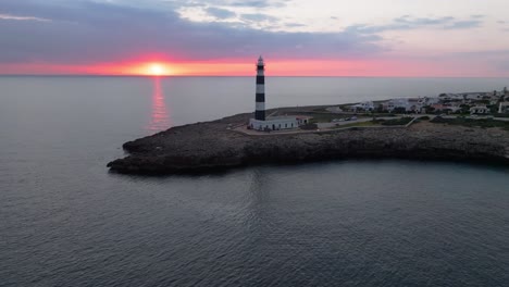 sunset aerial of cap d’artrutx lighthouse in menorca
