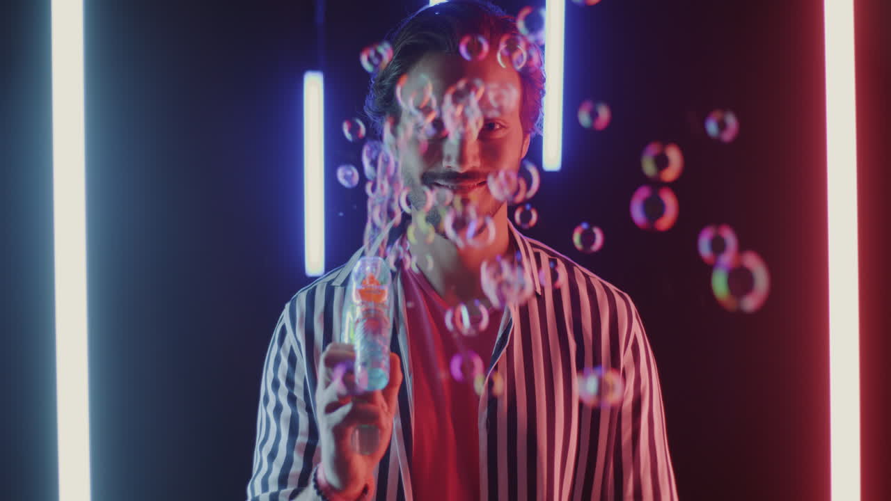 Man Blowing Bubbles in Neon Lights