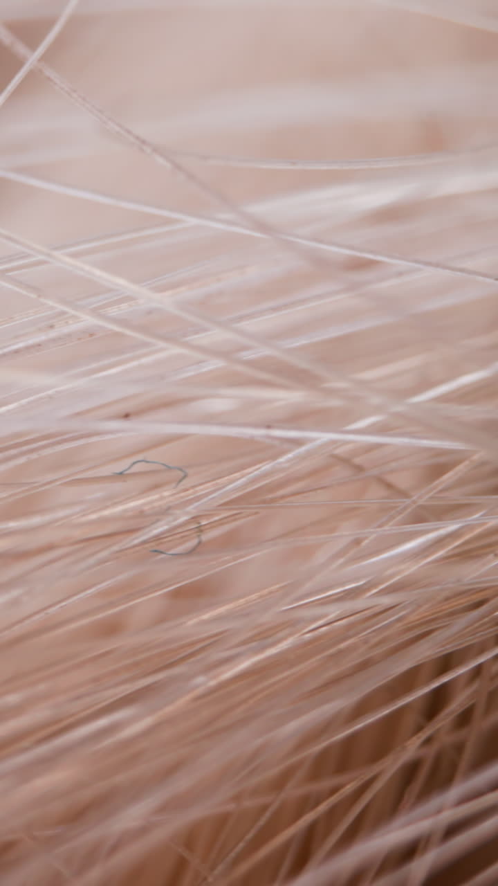 Synthetic light beige hair texture as background extreme close view. Decorative artificial fur material in studio. Supplies for design and craft