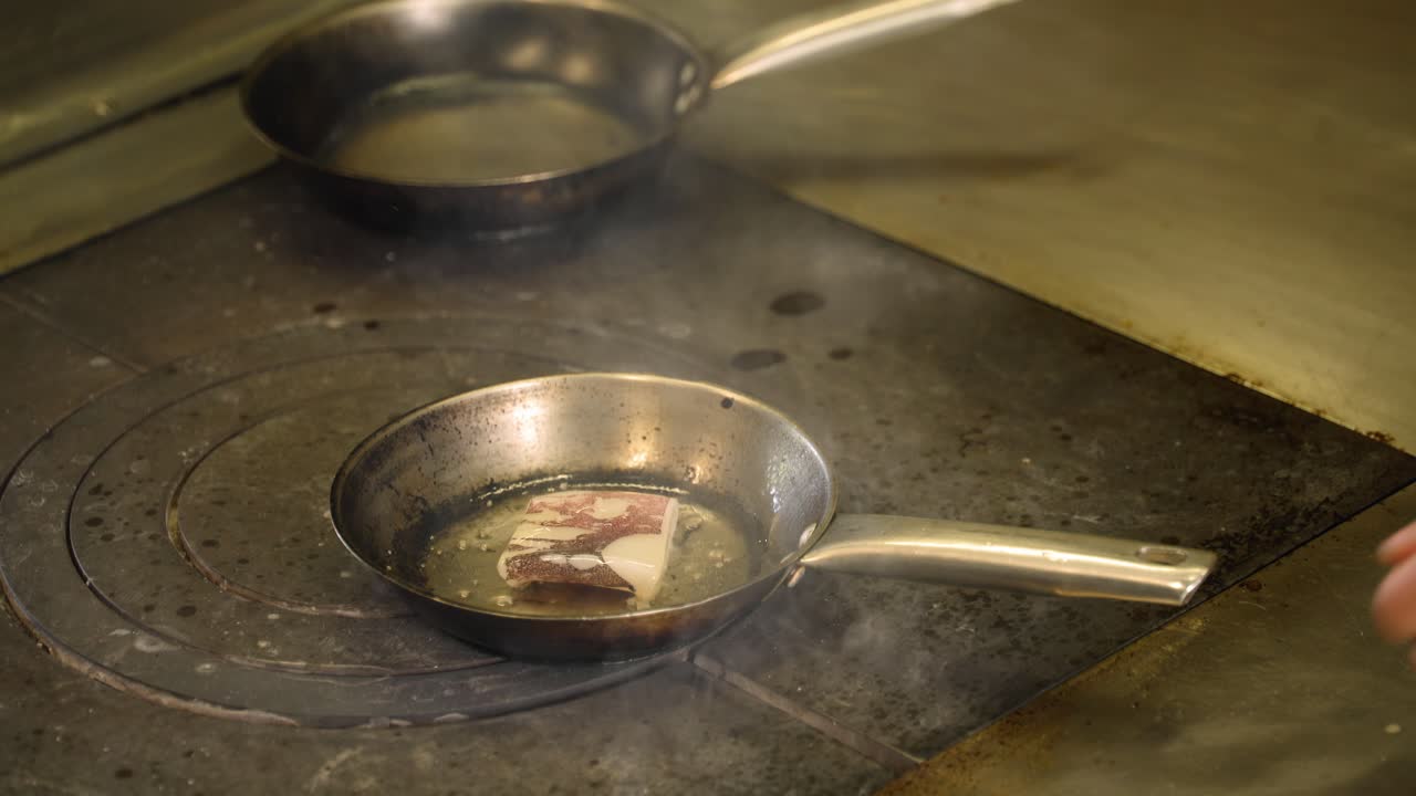 요리사는 작은 팬에서 음식을 조리하고 있다