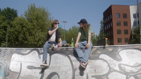 Caucasian-friends-talking-in-skatepark.