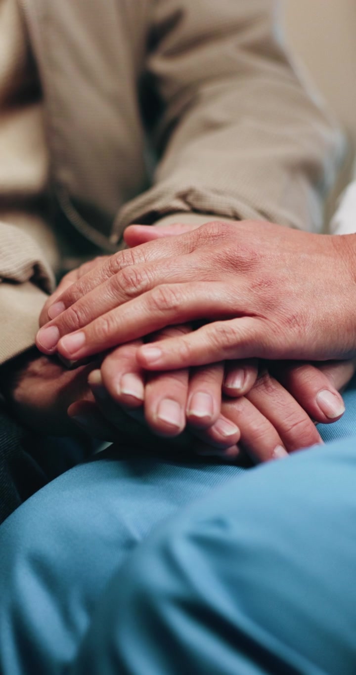 Enfermera sosteniendo las manos de un paciente anciano en el hospital