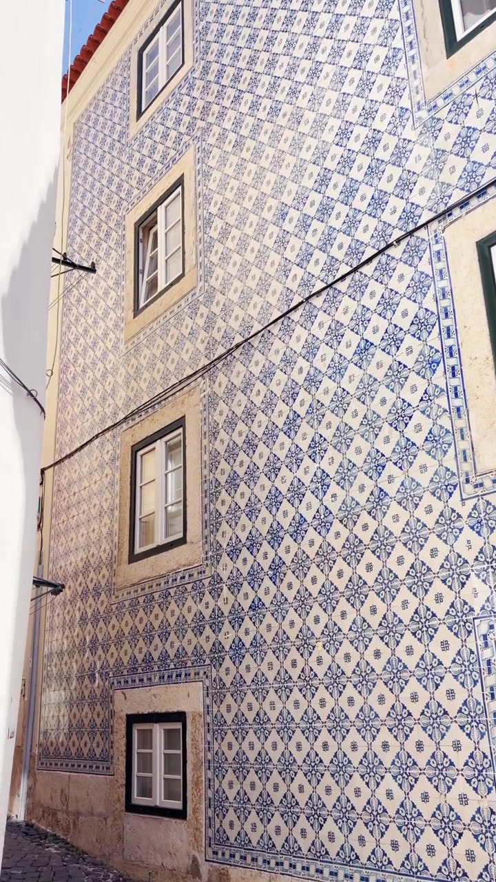 POV - Authentic building facade in city of Lisbon, Portugal, beautifully decorated with traditional blue and white azulejo ceramic tiles. Cultural heritage and unique architecture. UGC vertical reel