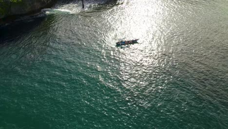 Exciting-small-fishing-boat-trip-on-shiny-ocean-aerial-view,-Indonesia