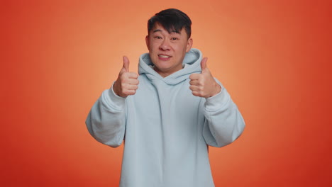 asian business man showing thumbs up and nodding in approval, successful good work, nice great job