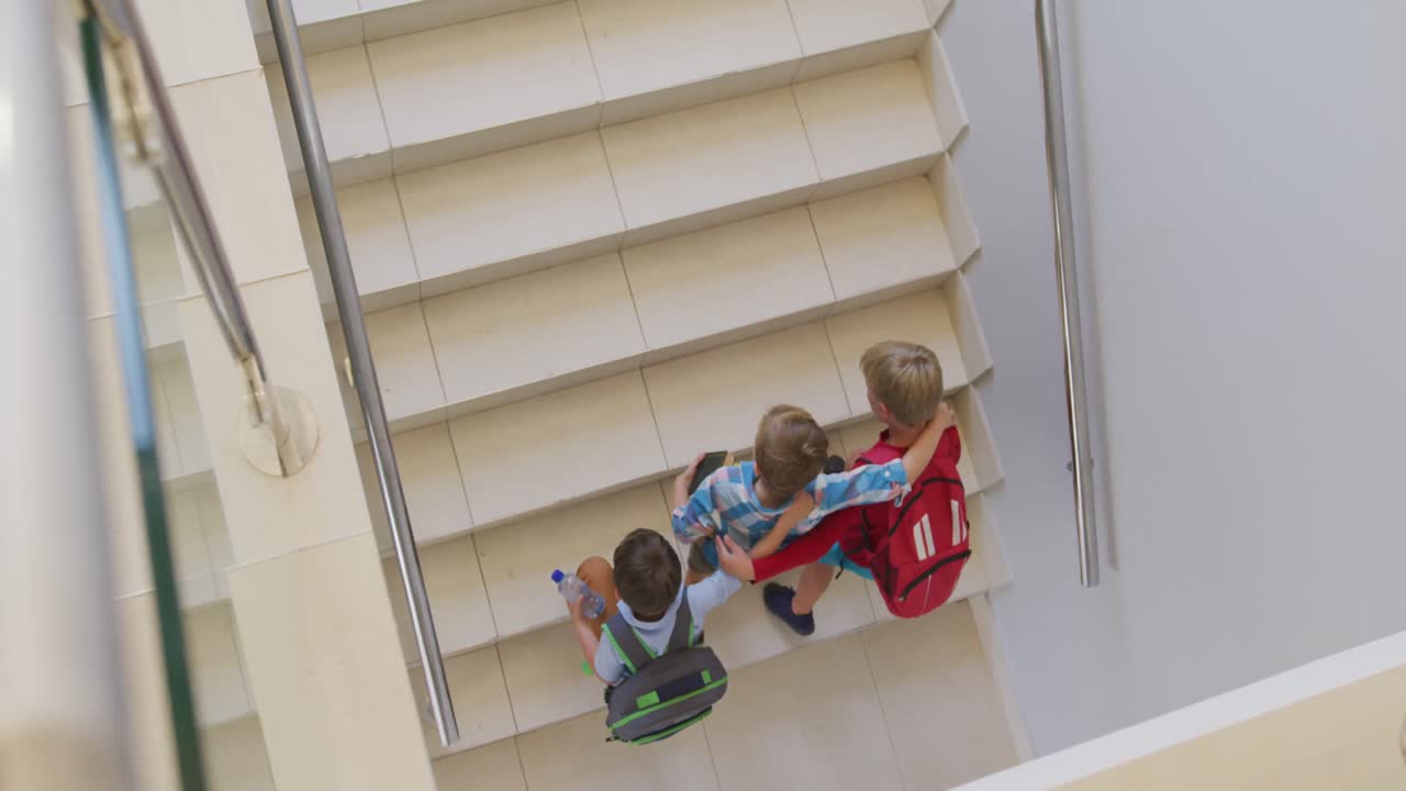 video de vista superior de niños caucásicos corriendo arriba en la escuela