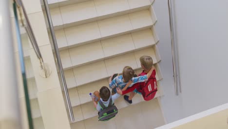 Video-Der-Draufsicht-Auf-Kaukasische-Jungen,-Die-In-Der-Schule-Die-Treppe-Hinauflaufen