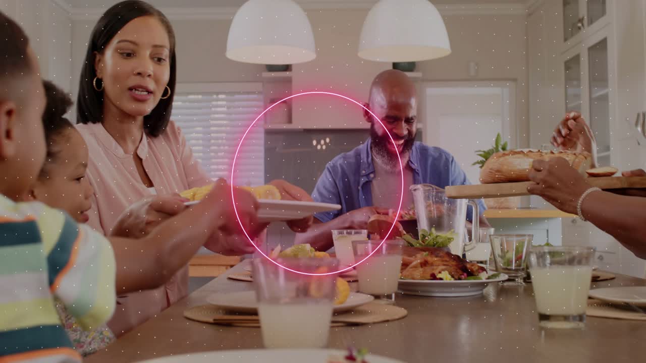 Senior woman laughing and reaching, sparking neon overlays marking hands while family sharing food