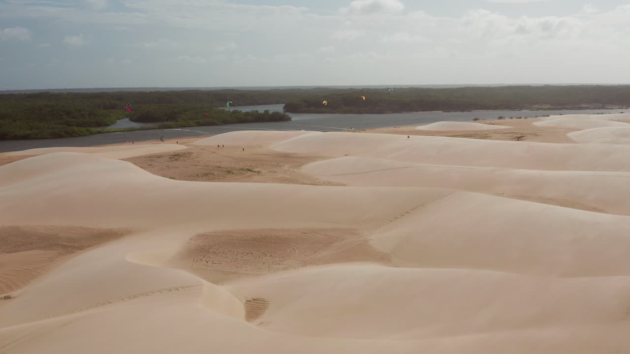 Sand dunes landscape with kite surfing on the river