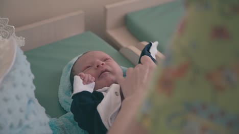 mommy-puts-little-tuxedo-on-newborn-baby-on-changing-table