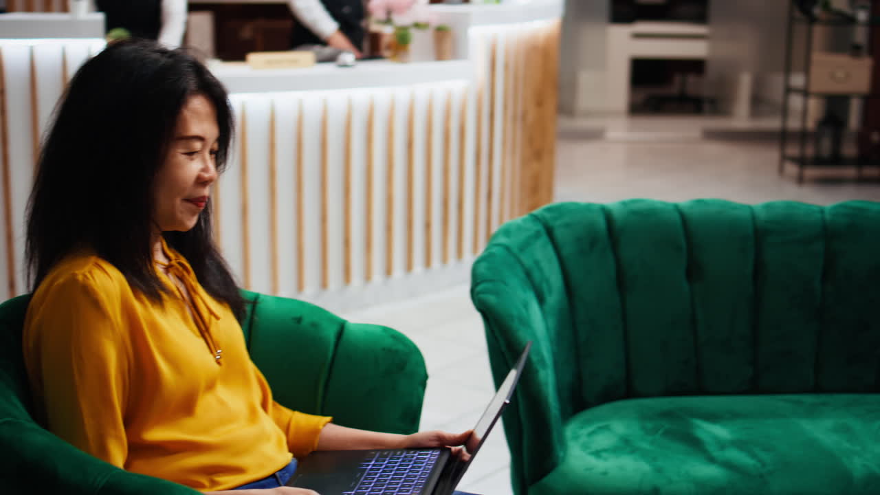 미소 짓는 여성은 호텔에서 pc에서 온라인 비디오 통화에 참석합니다.