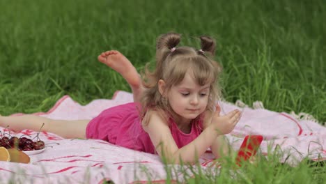 weekend at picnic. girl on grass meadow play online games on mobile phone. social network, chatting