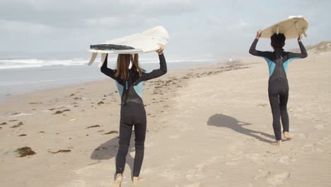 Nicht-Erkennbare-Kleinkinder-Mit-Surfbrett-Und-Neoprenanzug,-Die-Während-Einer-Erholungsaktivität-In-Den-Ferien-Am-Strand-Spazieren-Gehen