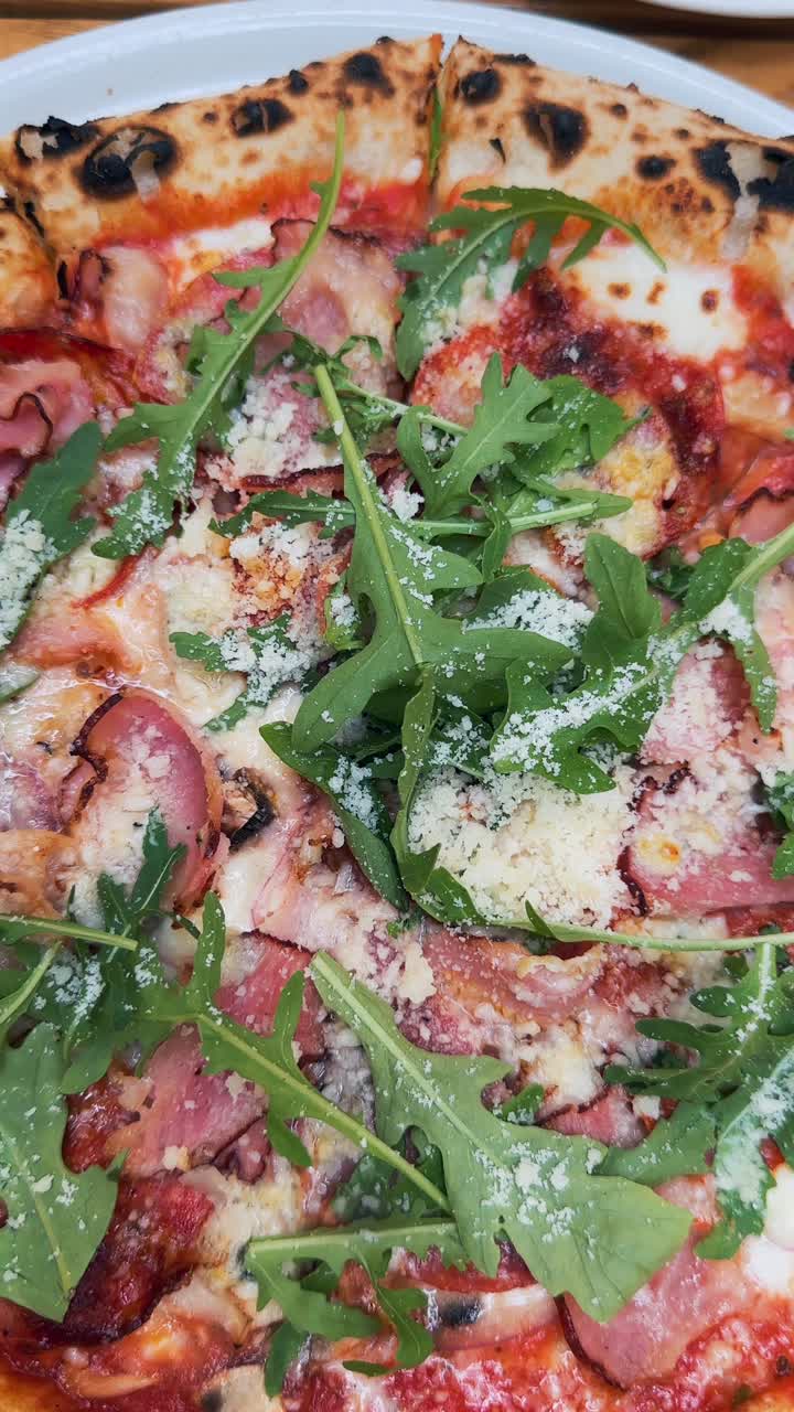 햄, 아루라, 파르메산 이 들어 있는 맛있는 피자 의 클로즈업