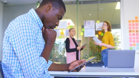 Side-view-of-young-black-male-executive-working-on-digital-tablet-in-modern-office-4k