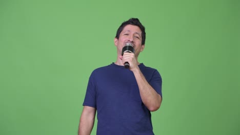 hispanic man singing on the microphone
