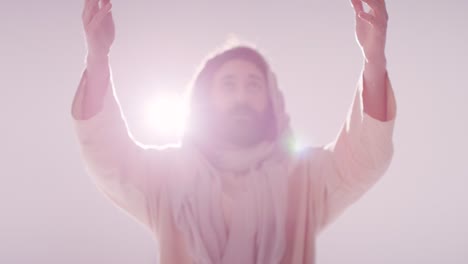 backlit portrait of man wearing robes with long hair and beard representing figure of jesus christ praying or preaching 1