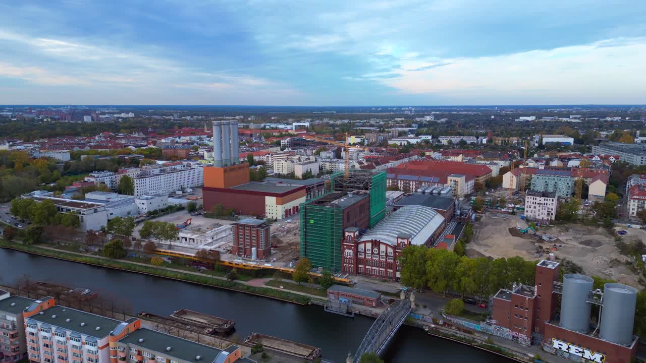 Kraftvärmeverk i stadsbilden vid floden Spree med nybyggnationer under uppbyggnad. Fantastisk flygbild med drönare som flyger baklänges