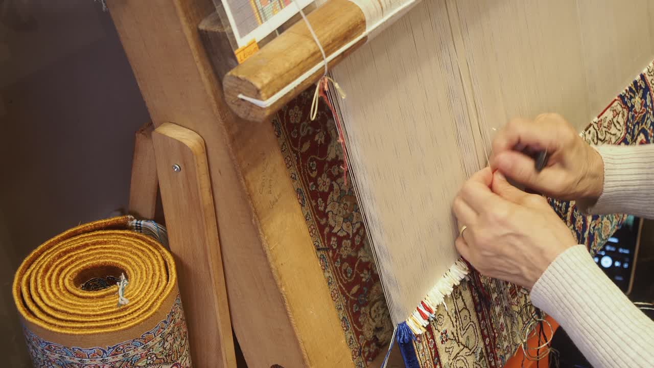 Close Up of Hands Weaving a Traditional Rug on a Loom