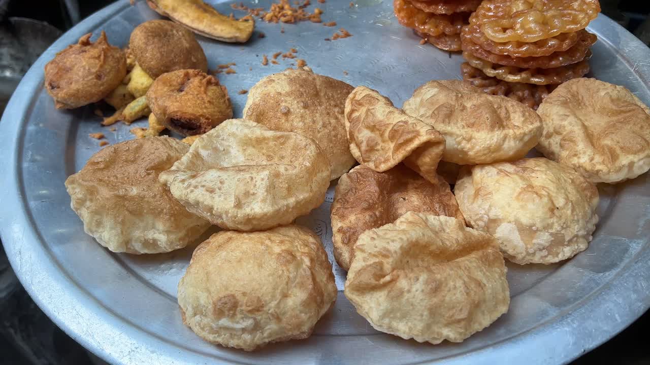 신선하게 준비된 카초리, 자레비, 파코라, 텔레 바자 (tele bhaja) 는 상점에서 전시되는 알루미 트레이에 있습니다.