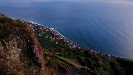 revelando uma pequena cidade depois de voar ao longo de um pico de montanha