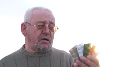 Senior man holding various medication blister packs