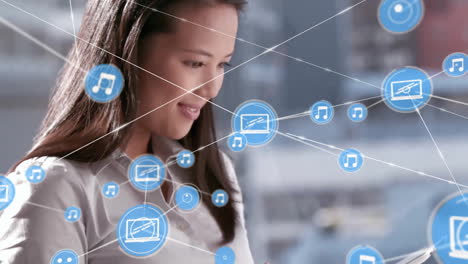 Animation of network of connections with icons over biracial businesswoman using tablet