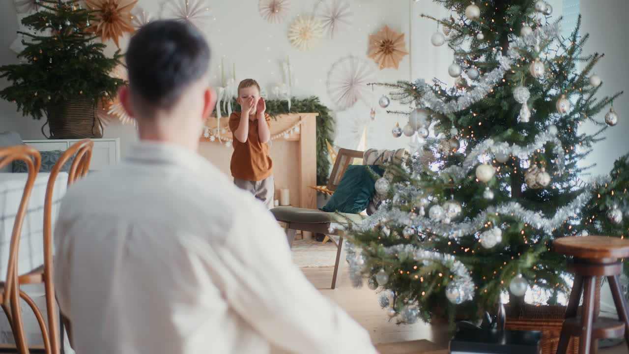 un niño pequeño corre a su padre durante la navidad