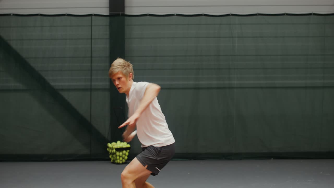 실내에서 테니스를 하는 남자