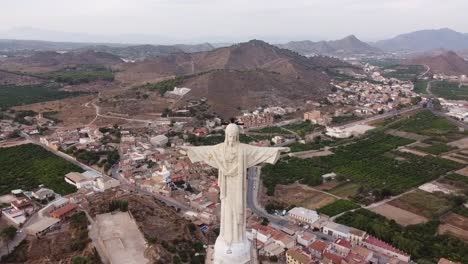 Gran-Estatua-De-Chirst-En-Monteagudo,-Cerca-De-La-Ciudad-De-Murcia,-Volando-Hacia-Atrás