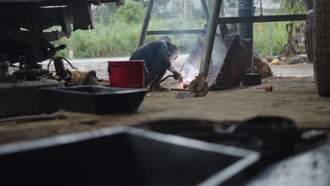 a worker welding metal parts in a workshop