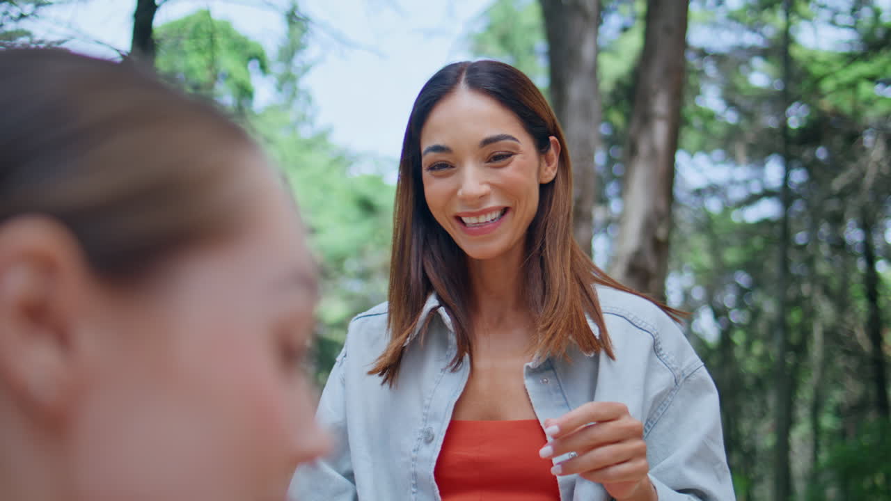 Portrait smiling brunette talking friends in forest. Cheerful woman enjoying